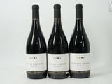 three bottles of wine sitting on top of a white table
