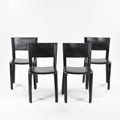 three black leather chairs sitting next to each other on a white surface