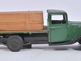 a green truck with a wooden box on the back of it