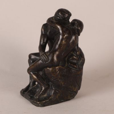 statue en bronze représentant un homme et une femme assis sur un rocher