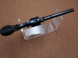 a black rifle on a clear stand on a brown surface