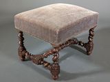 an antique foot stool with a brown velvet seat and wooden legs