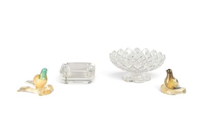 un bol en verre, un bougeoir et une figurine d'oiseau posés sur une surface blanche