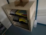 a small cabinet with a basket on top of it