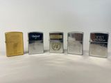 quatre briquets Zippo sont alignés sur une surface blanche