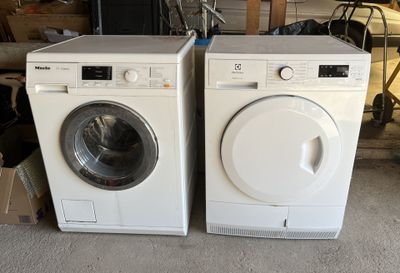 deux machines à laver blanches placées l'une à côté de l'autre dans un garage