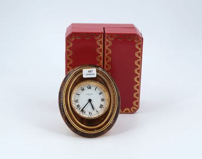 a small clock sitting next to a red box