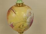 a vase with a painting on it sitting on a table