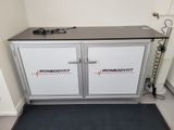 a metal cabinet with two doors and a black mat