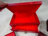 a person opening a red box on the floor