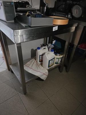 une table en acier inoxydable sur laquelle est posé un micro-ondes, dans une cuisine