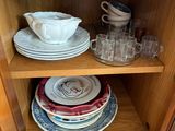 a wooden cabinet with plates and glasses on it
