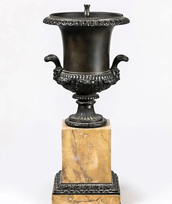 un vase noir posé sur un socle en marbre, sur fond blanc