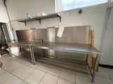 une grande cuisine en inox équipée d'un évier et d'une cuisinière