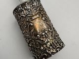 an antique silver metal lighter with a lion head on it