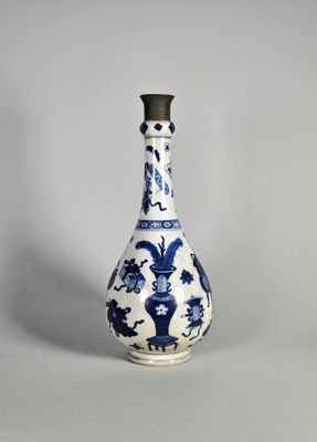 un vase bleu et blanc avec un couvercle noir posé sur une table