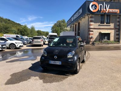 a small black car parked in front of a building