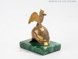 a statue of a bird sitting on top of a green marble base