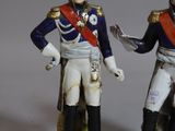 two figurines of two men dressed in military uniforms