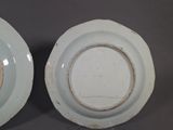two white plates with brown rims are sitting on a table