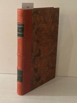 un livre rouge à la couverture verte posé sur une table blanche