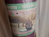 un rouleau de tapis de yoga violet dans une boîte en carton