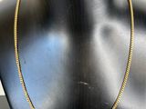 a black mannequin with a gold chain on it