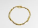un bracelet en or avec un fermoir en forme de serpent sur fond blanc