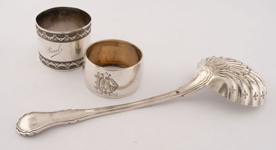 deux cuillères en argent et une tasse en argent posées sur un plateau blanc