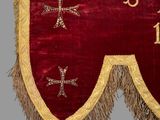 a close up of a red and gold banner with a cross on it