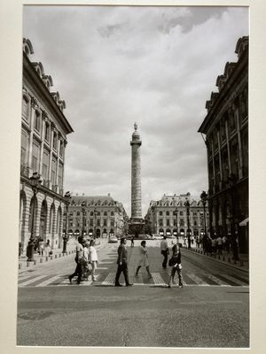 black and white photograph of people crossing the street in front of a clock tower
