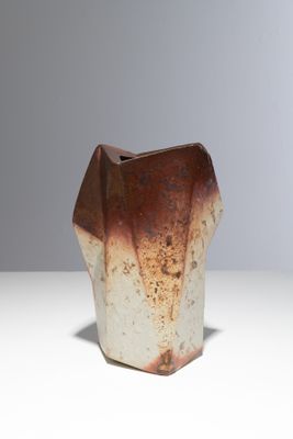 un vase brun et blanc posé sur une table