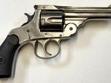 revolver posé sur une surface blanche, avec une crosse et une poignée noires