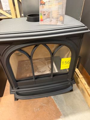 a black stove sitting in a room with a sign on it