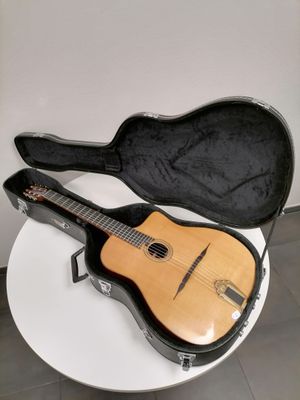 a guitar in a case sitting on a white table