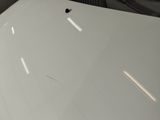 the hood of a white car with a hole in it