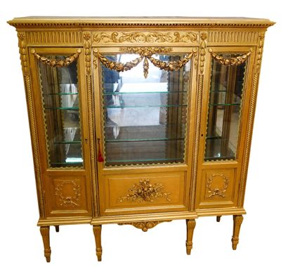 a gold display cabinet with glass doors and a mirror