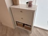 a picture of a white cabinet with baskets on top of it