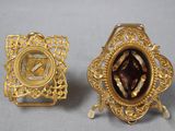 une paire de broches dorées représentant une femme en robe