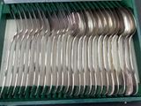 a lot of spoons and forks in a green case