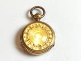 un petit cadenas en or sur lequel est gravée l'image d'une femme