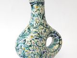 a blue and white vase with a bird on top of it
