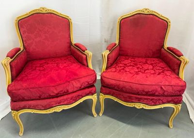 une paire de chaises rouges avec des finitions dorées et des finitions dorées