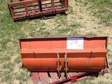 a plow sitting in the grass with a sign on it