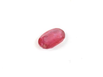 a red oval ruby stone on a white surface