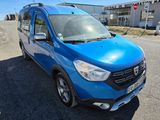 a blue van parked in a parking lot next to a building