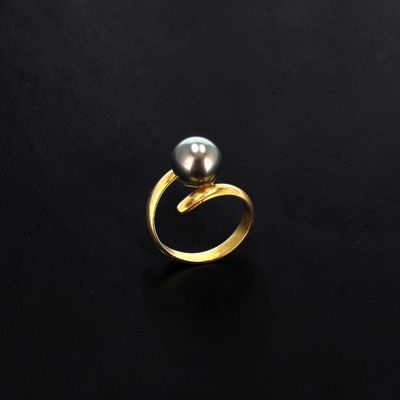 a gold ring with a black pearl on it