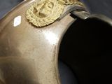 a brown vase with a gold decoration on the top of it