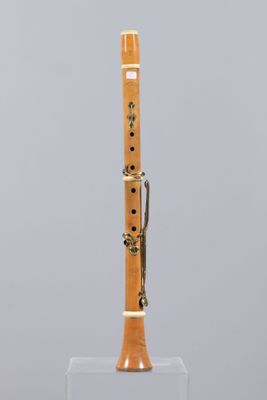 a close up of a wooden flute on a clear stand