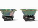 two bowls sitting on a stand on a white surface